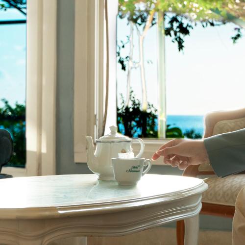 a tea kettle and a cup on a table at Hotel Sinuessa Terme in Mondragone