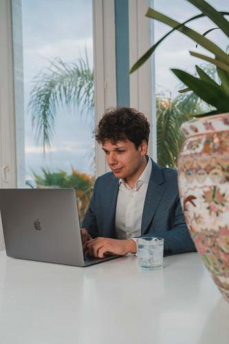 a man sitting at a table using a laptop computer at Hotel Sinuessa Terme in Mondragone
