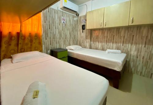 two beds in a small room with at Hotel Rancho Grande in Barranquilla