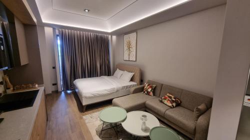 - un petit salon avec un canapé et un lit dans l'établissement The Diamond in City luxury suites by Cozy, à Accra