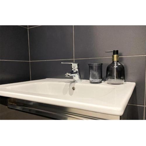 a white bathroom sink with a soap dispenser on it at Stunning stay 6 minutes from NEC and Birmingham Airport in Solihull