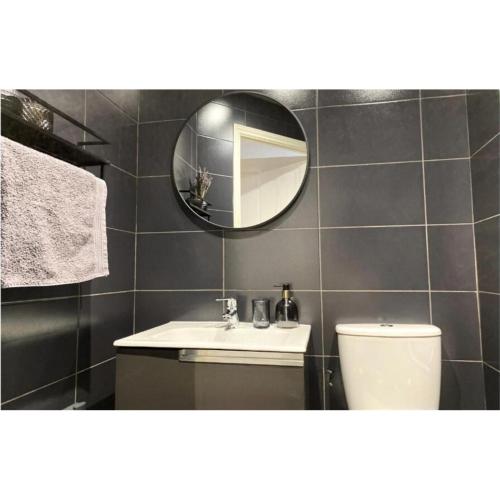 a bathroom with a sink and a mirror and a toilet at Stunning stay 6 minutes from NEC and Birmingham Airport in Solihull