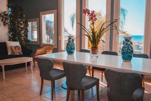 a dining room with a table with chairs and vases on it at Hotel Sinuessa Terme in Mondragone
