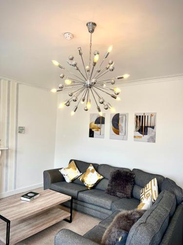 a living room with a couch and a chandelier at Private Parking, Urban Comfort & City Haven in Plymouth