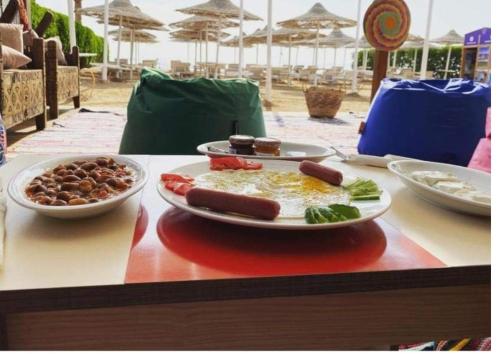 Sharm Hills Resort في شرم الشيخ: طاولة مع طبقين من الطعام على طاولة
