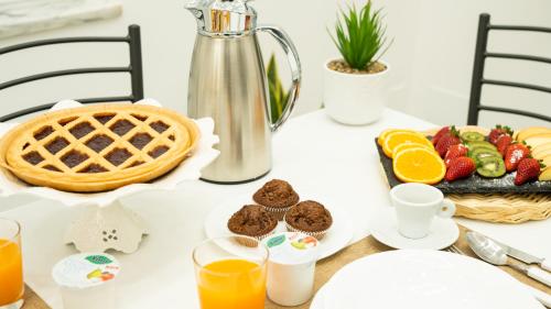 a table with a breakfast of fruit and orange juice at B&B Vaianfora Pompei in Pompei