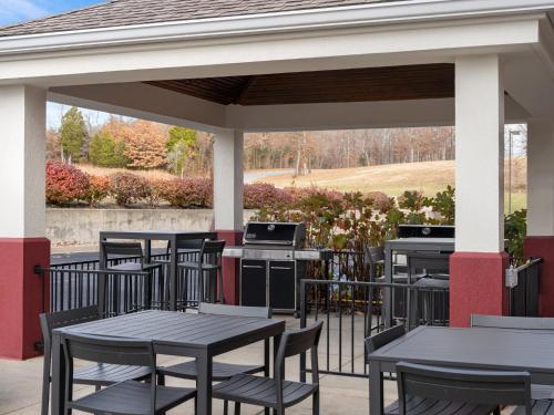 un patio con mesas, sillas y una parrilla en Candlewood Suites Radcliff - Fort Knox, an IHG Hotel, en Radcliff