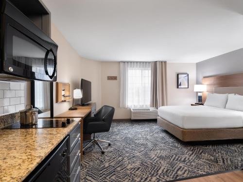 a hotel room with a bed and a kitchen at Candlewood Suites Radcliff - Fort Knox by IHG in Radcliff