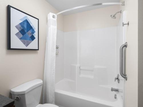 a bathroom with a white tub and a toilet at Candlewood Suites Radcliff - Fort Knox by IHG in Radcliff
