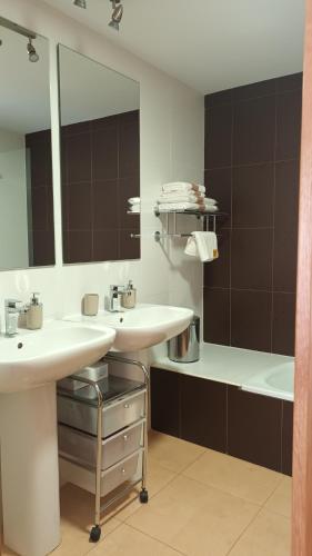 een badkamer met 2 wastafels, een bad en een spiegel bij Mar Menor Golf Resort Apartamento Luxury Bonsai in Torre-Pacheco