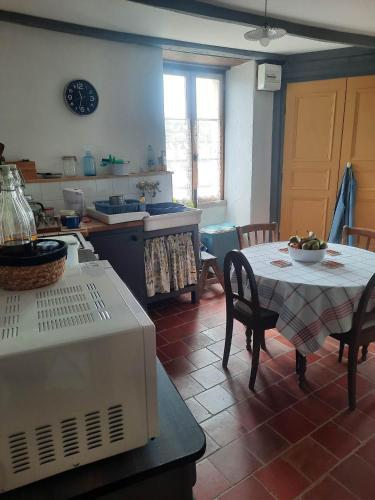 - une cuisine avec une table, une table et des chaises dans l'établissement La maison du Donjon, à Airvault