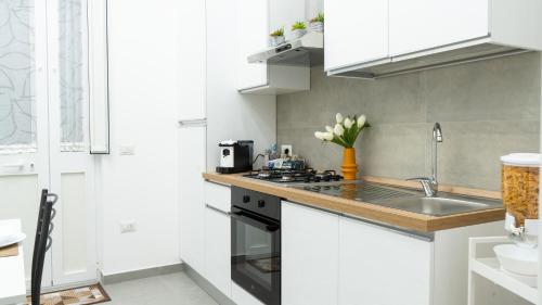 a white kitchen with a sink and a stove at B&B Vaianfora Pompei in Pompei