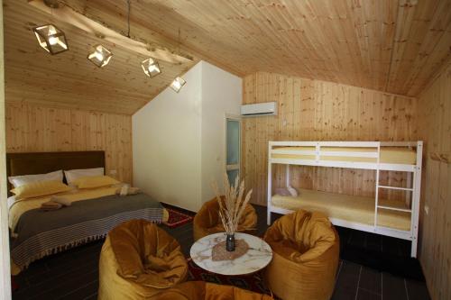 a bedroom with a bed and a bunk bed and chairs at Lugina e Shengjergjit ,Bujtinat in Tirana