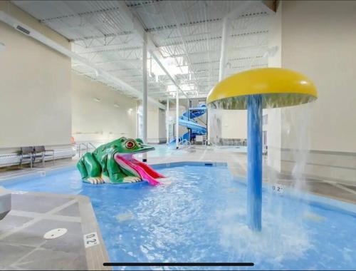 a pool with a plastic dinosaur in a water park at Cozy One Bedroom Condo with Indoor Pool and HotTub in Canmore