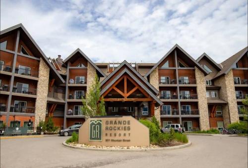 a large apartment building with a sign in front of it at Cozy One Bedroom Condo with Indoor Pool and HotTub in Canmore