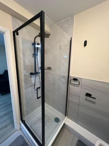 a shower with a glass door in a bathroom at studio flat in Spinney Hill