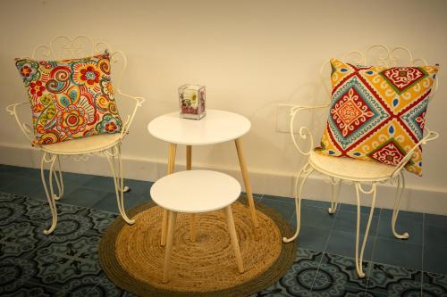 two chairs and a table and two pillows in a room at La Terrazza Nel Borgo B&B in Copertino