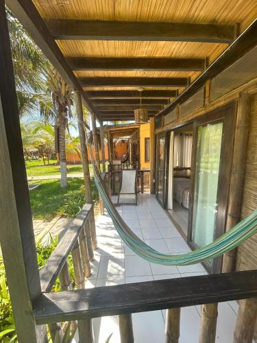 a hammock on the porch of a house at Punta Pacífico Bungalows Máncora in Máncora