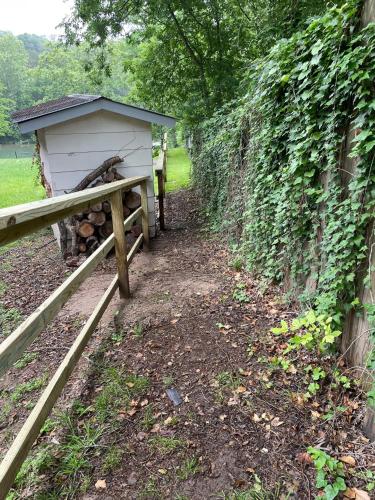 a wooden fence with a shed next to a wall at Pet friendly Tiny House Rental with new Access to Guadalupe River NBTX in New Braunfels