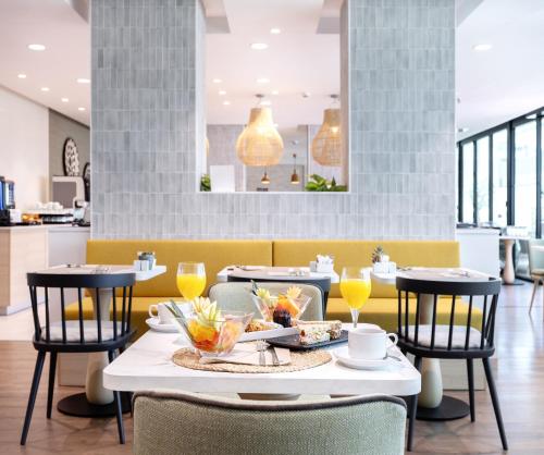 a dining room with a table with food and drinks at Hotel Málaga Alameda Centro Affiliated by Meliá in Málaga