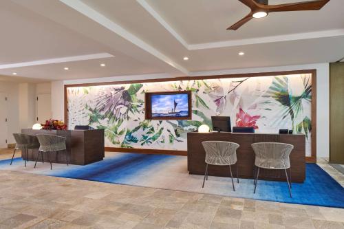 a lobby with a large mural of flowers on the wall at OUTRIGGER Kona Resort and Spa in Kailua-Kona