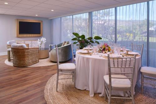 a dining room with a table and chairs and windows at OUTRIGGER Kona Resort and Spa in Kailua-Kona