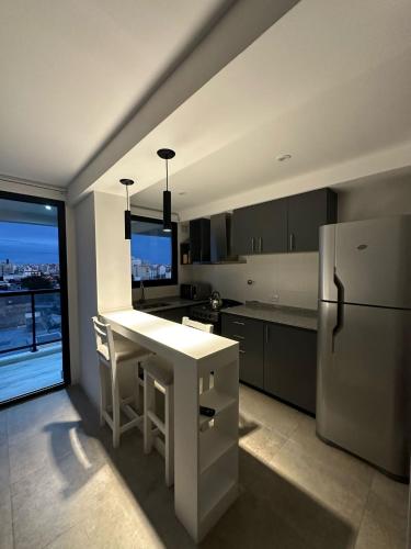 a kitchen with a white refrigerator and a table at Departamento Paso 3244 in Mar del Plata