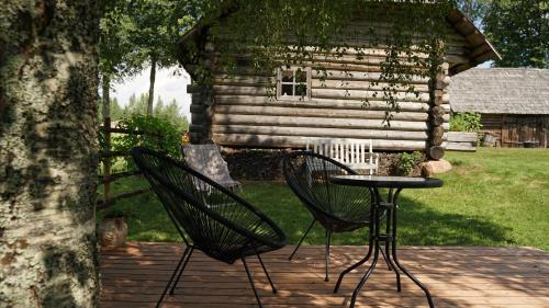two chairs and a table in front of a cabin at Hubane seto talu ait in Leimani