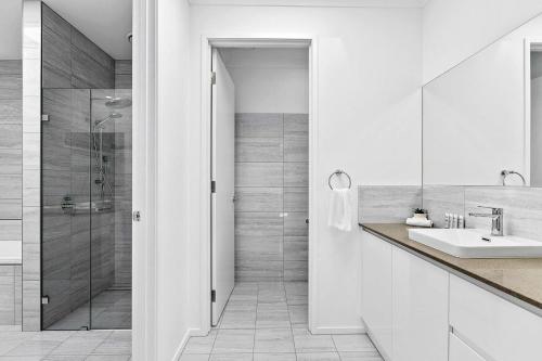 uma casa de banho branca com um chuveiro e um lavatório. em Zephyr Bayside Villas 4 bed em Scarness