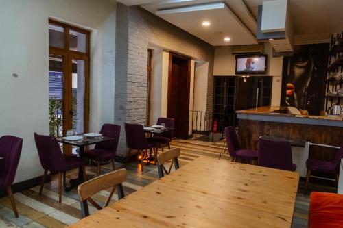 イスタンブールにあるEspinas Hotelの木製テーブルと紫色の椅子が備わるレストラン