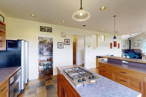 a kitchen with a stove top oven in a room at Sunset View House in Lopez