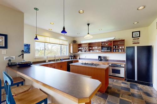 a kitchen with a large counter and a refrigerator at Sunset View House in Lopez
