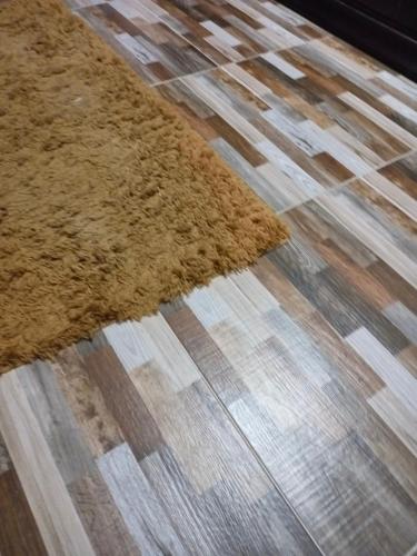 ein brauner Teppich auf einem Holzboden in der Unterkunft Masr om adonia in Kafr Şaqr