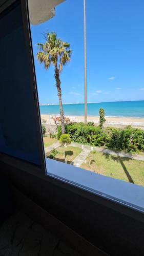 ein Fenster in einem Zimmer mit Blick auf den Strand in der Unterkunft la belle vue tanger R in Tangier