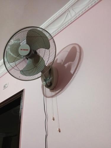 un ventilador colgando del techo de una habitación en Masr om adonia, en Kafr Şaqr