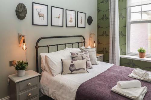 a bedroom with a bed with pillows and pictures on the wall at The Eastleigh in Seaton