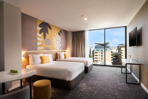 a hotel room with two beds and a large window at Crowne Plaza Adelaide by IHG in Adelaide