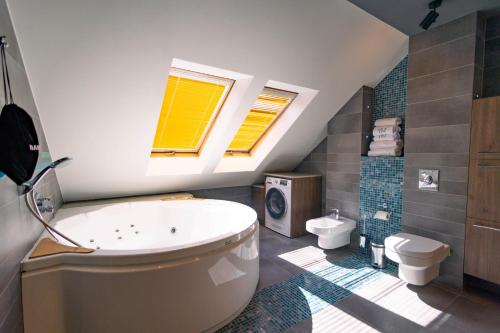 a bathroom with a large tub and a toilet at Boulevard Boutique Suites in Łeba