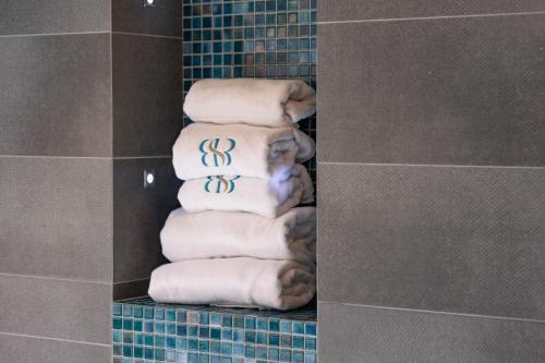 a stack of white towels in a bathroom at Boulevard Boutique Suites in Łeba