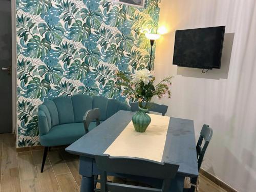 a dining room with a table and a vase with flowers at Sweet Lotus Apartment in Taormina