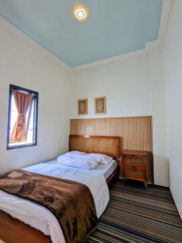 ein Schlafzimmer mit einem großen Bett und einem Fenster in der Unterkunft Homestay Lingga Yoni DIENG in Banjarnegara