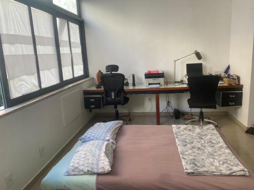 um quarto com uma cama e uma secretária com 2 cadeiras em Apartment Copacabana Beach no Rio de Janeiro