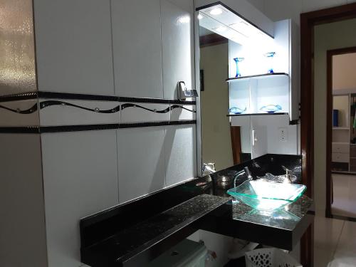 a bathroom with a sink and a mirror at Casa de Praia Massaguaçu! Ao meio Áreas Arborizadas in Caraguatatuba