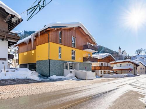 a building on a snowy street in a town at Emma Top 3 XL in Dienten am Hochkönig