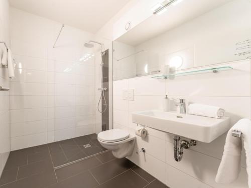a white bathroom with a toilet and a sink at Emma Top 3 in Dienten am Hochkönig
