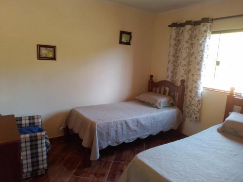 a bedroom with two beds and a window at Cantinho da Roça in Cunha