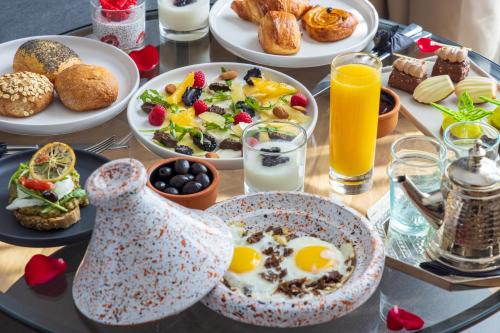 uma mesa de pequeno-almoço com alimentos de pequeno-almoço e bebidas em DIAGONAL HOTEL em Tânger