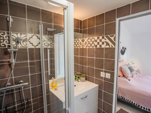 une salle de bain avec une douche, un lavabo et un miroir dans l'établissement Maison du Port, à Grimaud