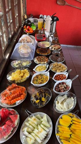 a table with many different types of food on it at Pousada Canto do sabiá Imbassaí in Imbassai