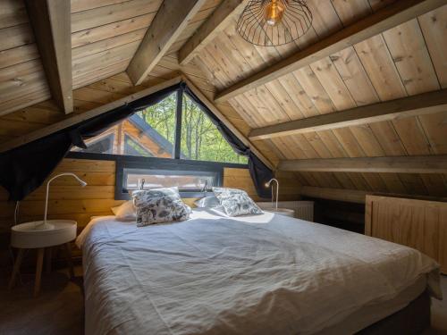 Un dormitorio con una cama grande en una habitación con techos de madera. en Amaryllis, en Soesterberg